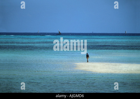 Einsame Figur zu Fuß auf einer Sandbank im türkisfarbenen Wasser Nungwi Nordspitze von Sansibar Tansania Ostafrika Stockfoto