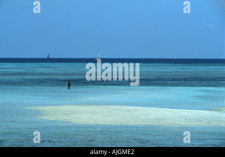 Einsame Figur zu Fuß auf einer Sandbank im türkisfarbenen Wasser Nungwi Nordspitze von Sansibar Tansania Ostafrika Stockfoto