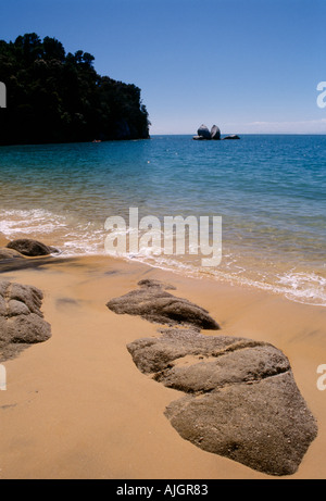 Split Apple Rock, Abel Tasman National Park, Neuseeland. Fernblick über die Split Rock vom Strand in einer kleinen, ruhigen Bucht. Stockfoto