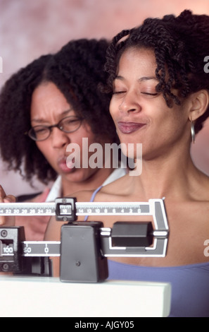 Afrikanische amerikanische Frau, die stolz auf ihr Gewicht beeindruckend Freund Stockfoto