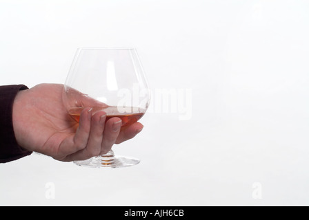 Hand hält ein Glas Schnaps Cognac Stockfoto