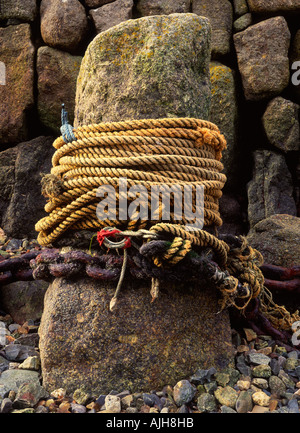 Granit-Capstan im Hafen mit Seilen umwickelt an Mousehole, West Penwith, Cornwall, England. Stockfoto