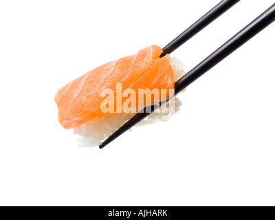 Nigiri Sushi mit Lachs statt zwischen zwei schwarzen Stäbchen, isoliert, weißen Hintergrund Stockfoto