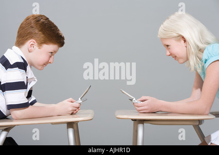 Mädchen und jungen, die Benutzung von Mobiltelefonen Stockfoto