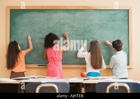 Schülerinnen und Schüler auf eine Tafel schreiben Stockfoto