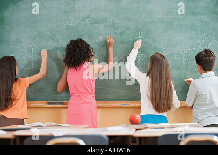 Schülerinnen und Schüler auf eine Tafel schreiben Stockfoto