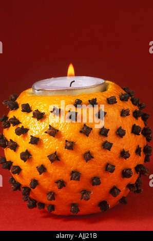 Orange Pomander mit eine brennende Kerze Stockfoto