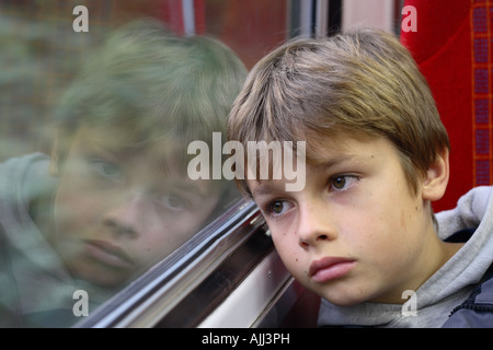 Jungen im Alter von 11 Jahren schauen traurig unglücklich Reisen auf Zug Stockfoto