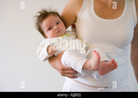 Baby mit viel Haare am Arm Mütter Stockfoto