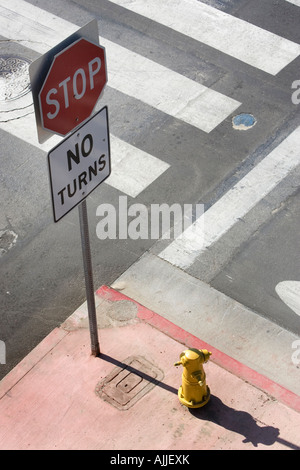 Amerikanische keine Kurven und Stop-Schild neben einem Fußgängerüberweg mit einem gelben Hydranten in Santa Monica, Kalifornien, USA. Stockfoto