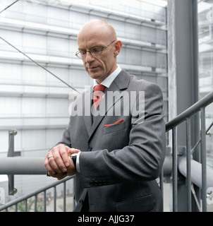 Geschäftsmann sucht auf seine Uhr Stockfoto