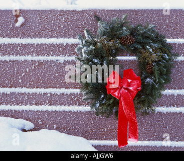 Weihnachtskranz hängen am Zaun mit roten Bogen Winter Portrait Stockfoto