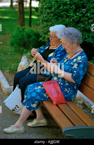 Zwei alte Damen stricken auf einer Parkbank in der Parc des Arenes, Cimiez, Nizza an der Cote d ' Azur - Cote d ' Azur Stockfoto