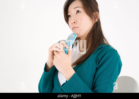 Junge Frau Holding Handy Stockfoto