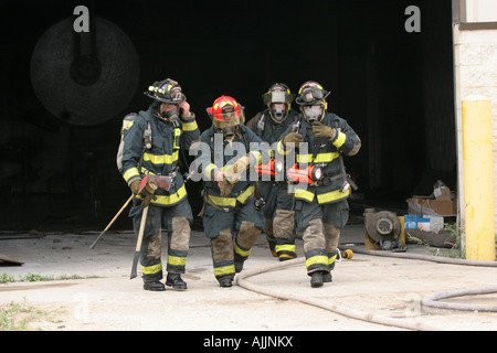 Feuerwehr verlassen eine Feuer-Szene im Inneren eines Gebäudes Stockfoto