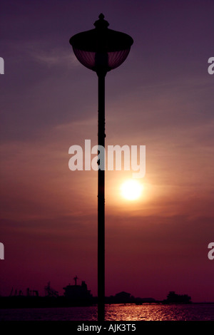 Eine Nahaufnahme von einem Laternenpfahl mit der untergehenden Sonne als Kulisse Stockfoto