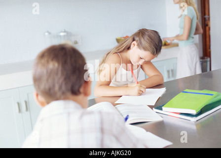 Kinder, die Hausaufgaben in der Küche Stockfoto