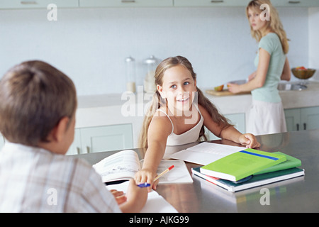 Mutter, die gerade Kinder Hausaufgaben Stockfoto