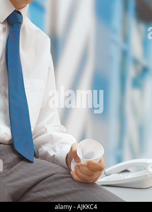 Mann, die Tasse in der Hand zerkleinern Stockfoto