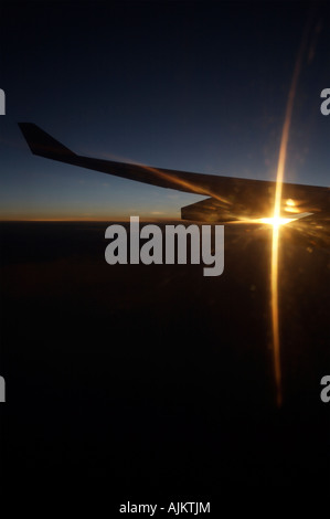 Tragfläche mit dramatischen Sonnenuntergang Starburst glitzerte durch den Motor und Wolken Stockfoto