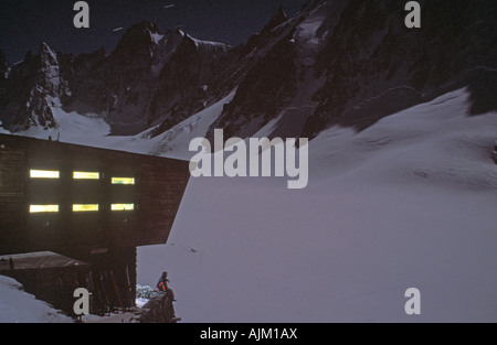 Mann sitzt auf einer Mauer außerhalb der Refuge D Argentiere-Frankreich Stockfoto