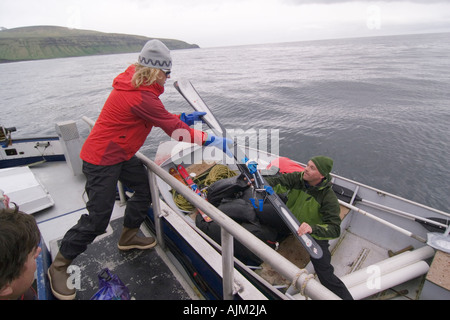 Laden Ihre Skiausrüstung in einem Skiff in den Aleuten in Alaska Stockfoto