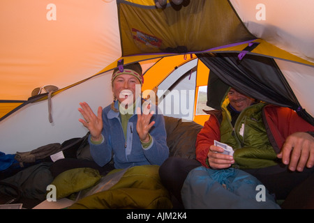 Freunde-Spielkarten in einem Zelt beim camping in den Aleuten Alaska Stockfoto