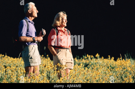 Älteres Paar mit dem Fernglas an Wildblumen Stockfoto