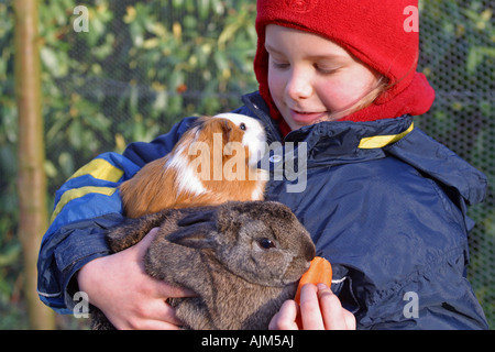 Mädchen mit Meerschweinchen und Kaninchen auf dem Arm Stockfoto