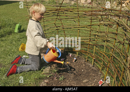 junge macht seine eigenen Patch im Garten und Radieschen säen Stockfoto