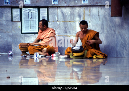 Mönche essen ihre letzte Mahlzeit des Tages in der Tiger Cave Wald Wat in der Nähe von Krabi in Südthailand Stockfoto