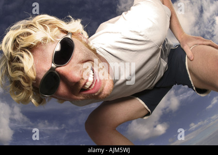 junger blonder Mann mit Sonnenbrille, Camer lachen Stockfoto