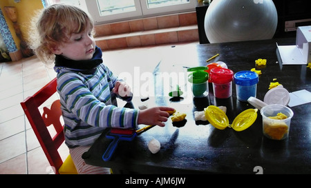 kleiner Junge spielt mit Knetmasse Stockfoto