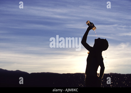 Eine Frau gießt Wasser auf ihren Kopf nach der Ausführung Stockfoto