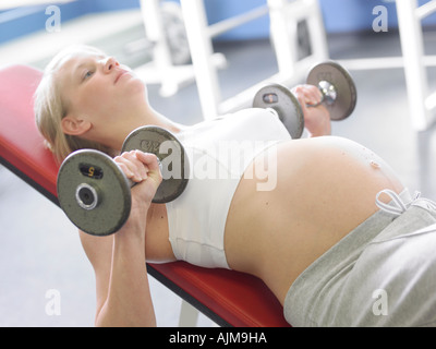 Schwangere Frau in der Turnhalle eine geneigte Dumbell Brust drücken Stockfoto