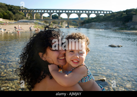 Mutter und Kind in einem Bikini Leben... am Pont du Gard im Urlaub in Frankreich zu lieben. Umarmen und kuscheln wie Schwestern Stockfoto