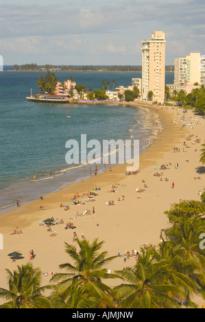 San Juan Puerto Rico Isla Verde beach mit Sonnenanbeter, blauer Himmel und Resort-Hotels im Hintergrund, Plam Bäume säumen Strand, Antenne Stockfoto