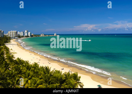 San Juan Puerto Rico Isla Verde beach mit Sonnenanbeter, blauer Himmel und Resort-Hotels im Hintergrund, Plam Bäume säumen Strand, Antenne Stockfoto