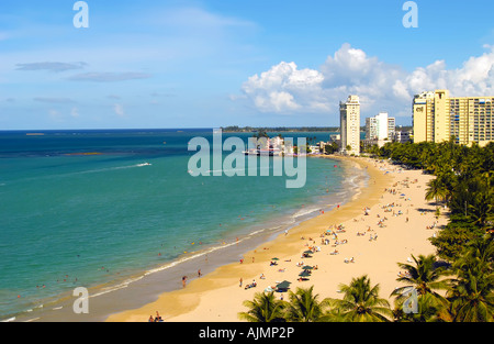 San Juan Puerto Rico Isla Verde beach mit Sonnenanbeter, blauer Himmel und Resort-Hotels im Hintergrund, Plam Bäume säumen Strand, Antenne Stockfoto