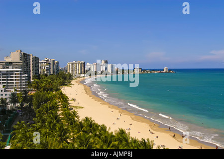 San Juan Puerto Rico Isla Verde beach mit Sonnenanbeter, blauer Himmel und Resort-Hotels im Hintergrund, Plam Bäume säumen Strand, Antenne Stockfoto