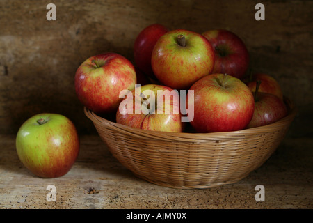 Äpfel in einem Korb einer lose auf einem rustikalen hölzernen Hintergrund Stockfoto