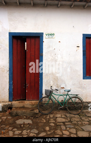 Fassade von einer bescheidenen Haus in Paraty, Brasilien. Ein altes Fahrrad ist vor der Tür geparkt. Stockfoto