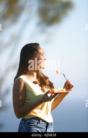Frau Obst im Freien zu essen Stockfoto