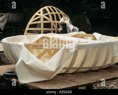 CORACLE machen Baumwolle Kattun Kursmaterial ist gestreckt und um Ash Holzrahmen des Bootes gefaltet dann geheftet Stockfoto