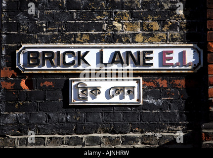 Eine Straße Zeichen der Brick Lane in Englisch und Bengali auf einem geritten Graffitiwand in Brick Lane East London Vereinigtes Königreich Stockfoto