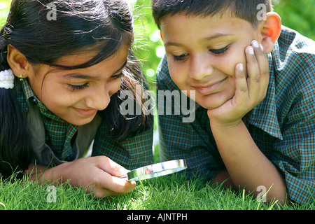 Zwei Schulkinder experimentieren mit einer Lupe Stockfoto