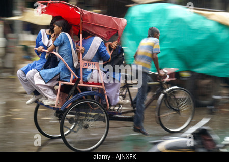 Fahrrad Rikscha Pedal Taxi Cab Reiten Gruppe Mädchen Passagiere bei Street in New Delhi, Indien Stockfoto