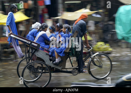 Fahrrad Rikscha Pedal Taxi Cab Reiten Gruppe Mädchen Passagiere bei Street in New Delhi, Indien Stockfoto