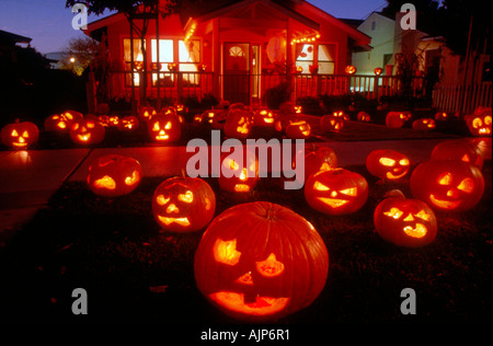 Beleuchtete Halloween Kürbisse auf einen Vorgarten eines Hauses. Stockfoto