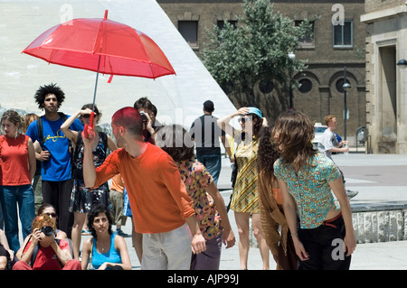 Akteure in einem zeitgenössischen Streetdance-Festival. Spektakel mit roten Regenschirm.  Plaza del Pilar, Zaragoza, Aragón, Spanien. Stockfoto